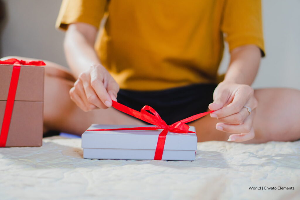 La magia de regalar libros: 4 librerías independientes de Bogotá para sorprender esta Navidad 3 regalar libros, librerías independientes en Bogotá, persona destapando regalo de Navidad, Más Colombia
