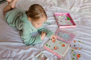 ideas para marcar cuadernos, niña colocando calcomanías en su cuaderno, Más Colombia