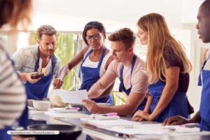 cursos de cocina en Bogotá, Grupo diverso aprendiendo habilidades culinarias en clase, Más Colombia