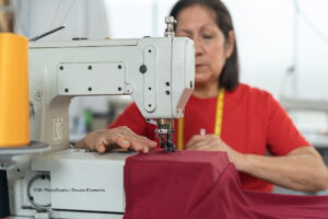 violencia de género, trabajo no remunerado, señora cosiendo en máquina de coser, Más Colombia