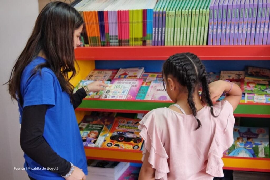 6 nuevas bibliotecas en Bogotá fueron habilitadas en Centros Proteger para promover la lectura infantil 4 nuevas bibliotecas en Bogotá, Dos niñas compartiendo e interactuando en una biblioteca, Más Colombia