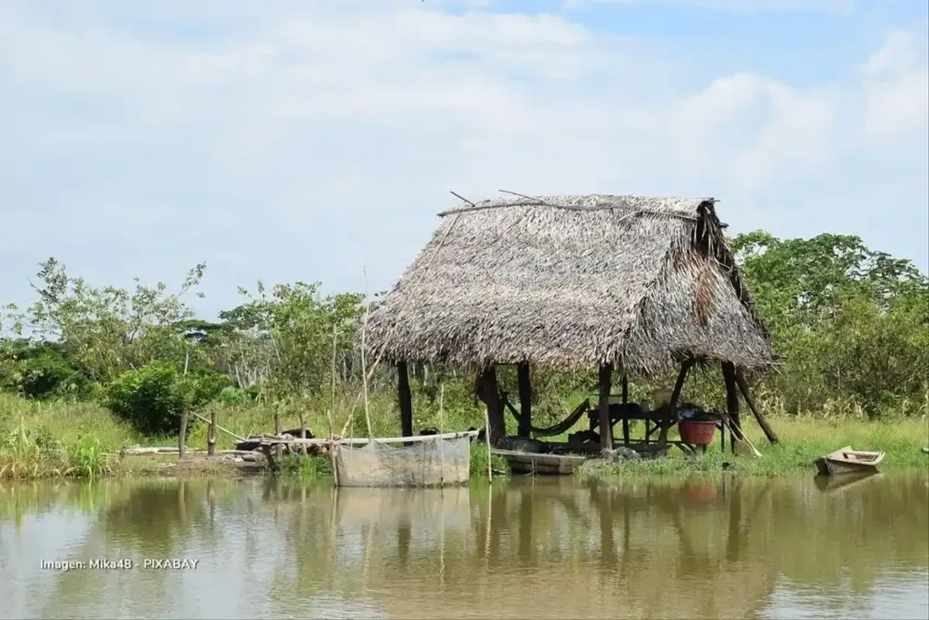 Choza tradicional de palma sobre el río Amazonas en medio de la selva.