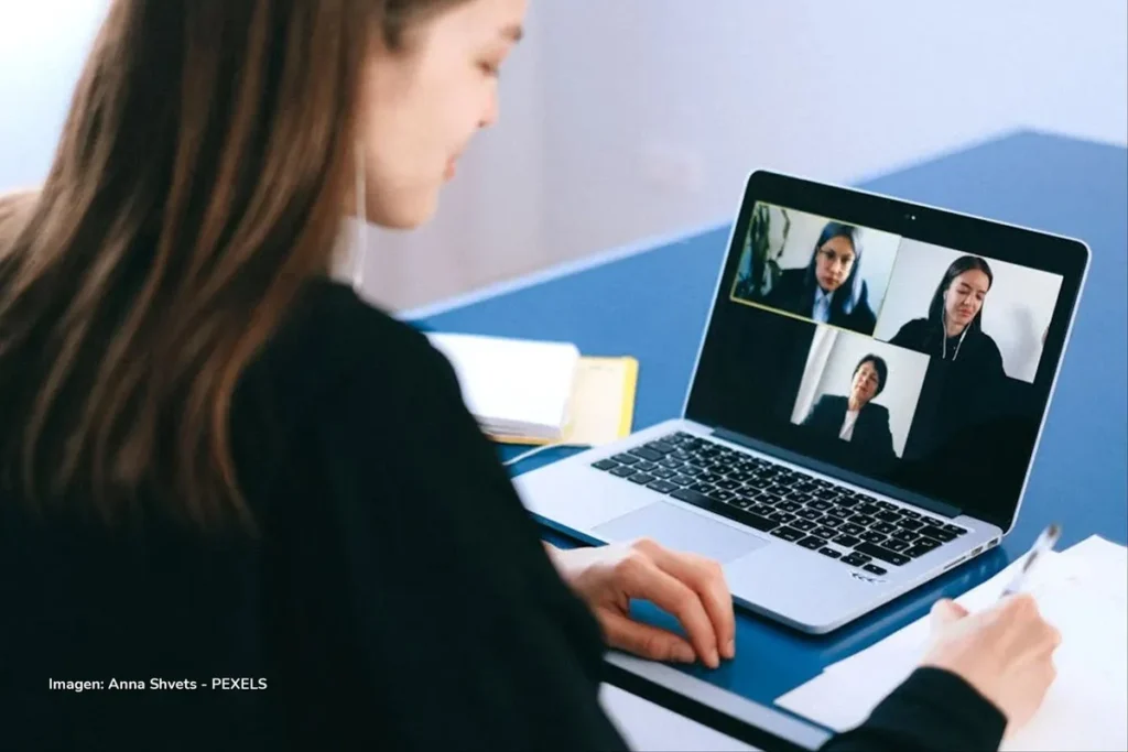 Estudiante en videollamada de clase en portátil; habla inglés en línea.