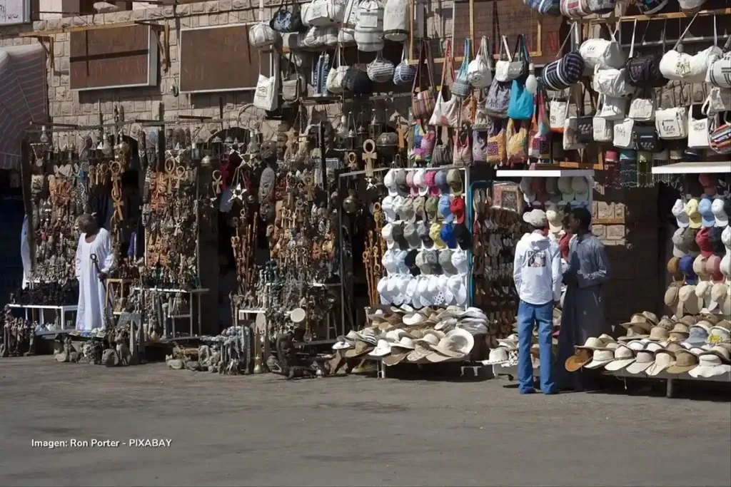 En la economía popular las colombianas ganan menos y trabajan más 3 Puestos callejeros con sombreros, bolsos y artesanías atendidos por vendedores, relacionados con la economía del cuidado y la informalidad.