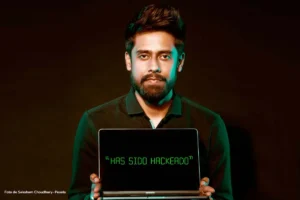 Hombre sostiene portátil con mensaje “HAS SIDO HACKEADO” como advertencia de ciberseguridad.
