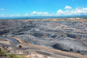 Mina de carbón a cielo abierto en Colombia en contraste con el avance de energías renovables.