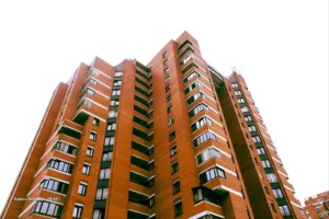 Edificio de apartamentos de ladrillo visto desde abajo contra el cielo, ejemplo de proyectos de vivienda VIS en Colombia.