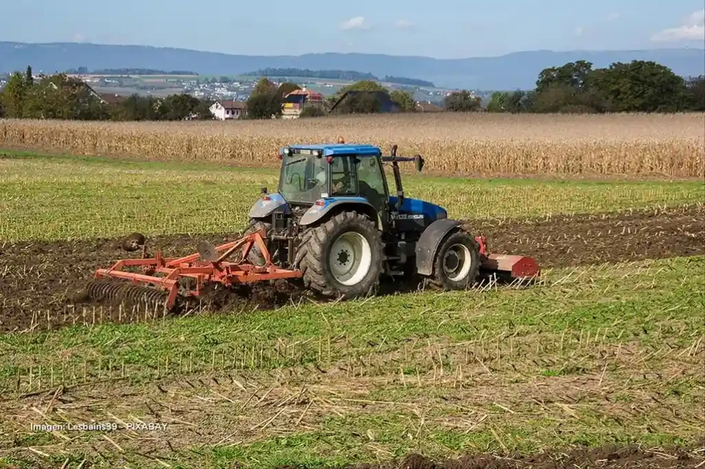 Tractor arando un campo agrícola en Colombia dentro de las actividades productivas medidas por el ISE.