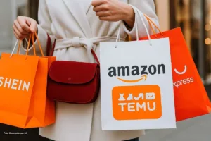 Mujer sostiene bolsas de compras de Shein, Temu, Amazon y AliExpress, símbolo de importaciones afectadas por la Reforma Tributaria.