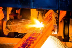 Producción en la industria del acero en Colombia con chispas de soldadura en una planta siderúrgica.