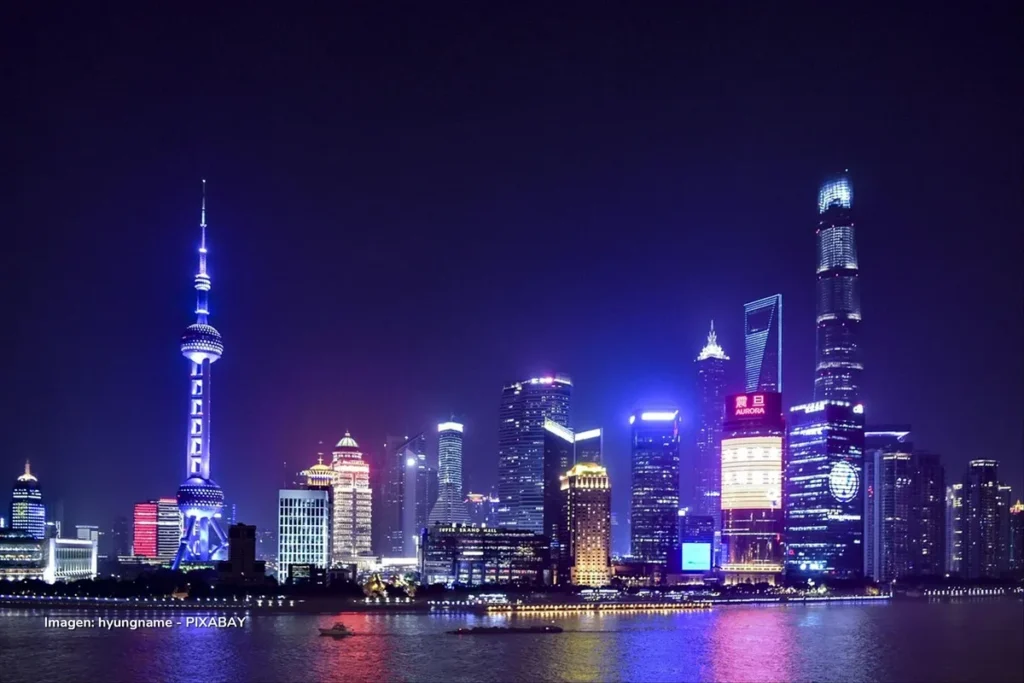 Importaciones chinas iluminan el horizonte económico con vista nocturna de Shanghái y su distrito financiero.