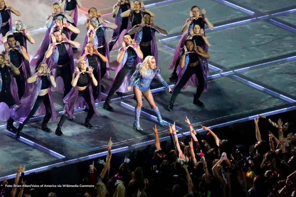 Lady Gaga con traje brillante azul liderando coreografía en el Super Bowl 2017