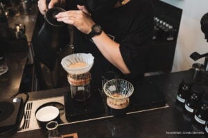 Todo listo para Cafés de Colombia Expo 2025: así será la feria cafetera más grande del país 5 Cafés de Colombia Expo 2025, hombre en Cafés de Colombia Expo 2025 sirviendo café por goteo, Más Colombia