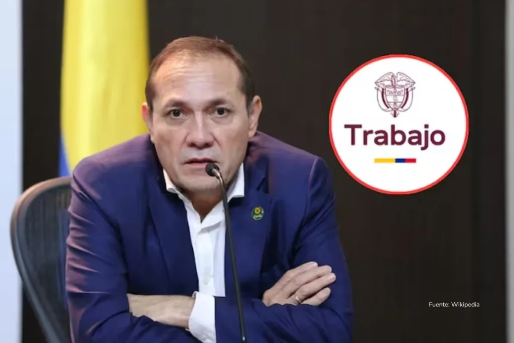 Hombre en traje habla frente a un micrófono durante una declaración oficial, con un emblema institucional del Ministerio de Trabajo al fondo.