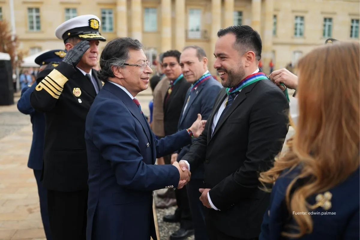 Reforma Energética Colombia. Autoridades civiles y militares participan en una ceremonia formal al aire libre, donde un hombre entrega una condecoración a otro asistente.