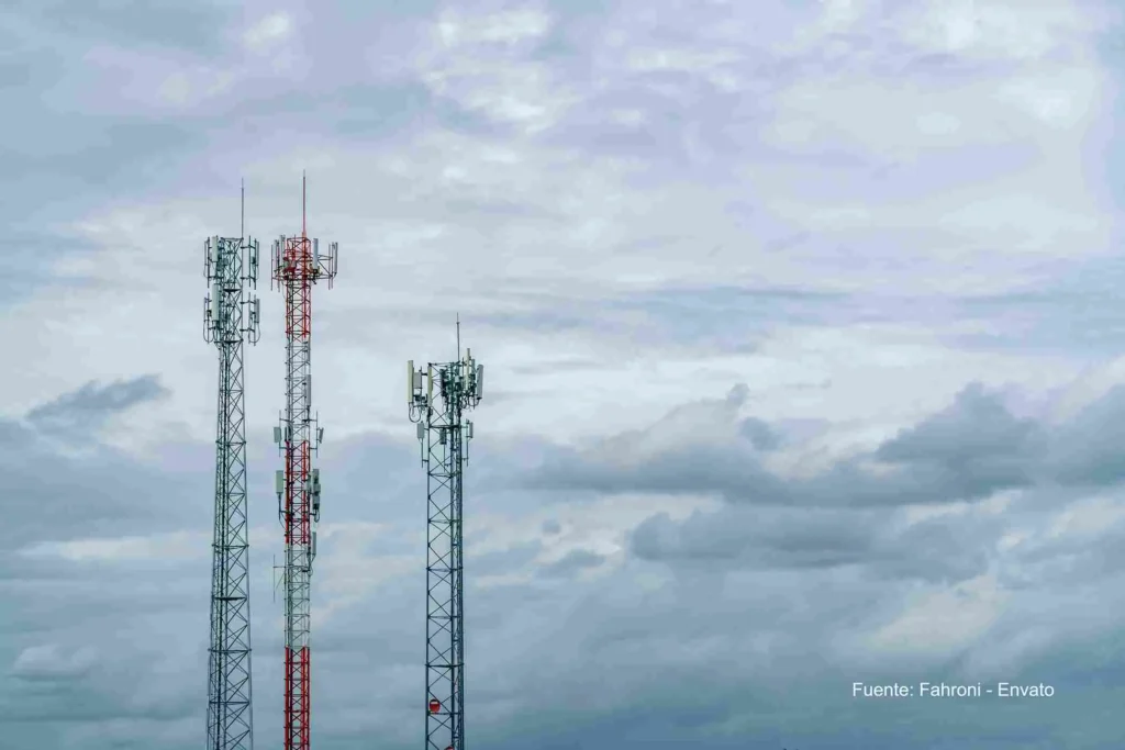Torres de telecomunicaciones se elevan sobre un cielo nublado, símbolo de la infraestructura móvil en Colombia. Integración Tigo Movistar