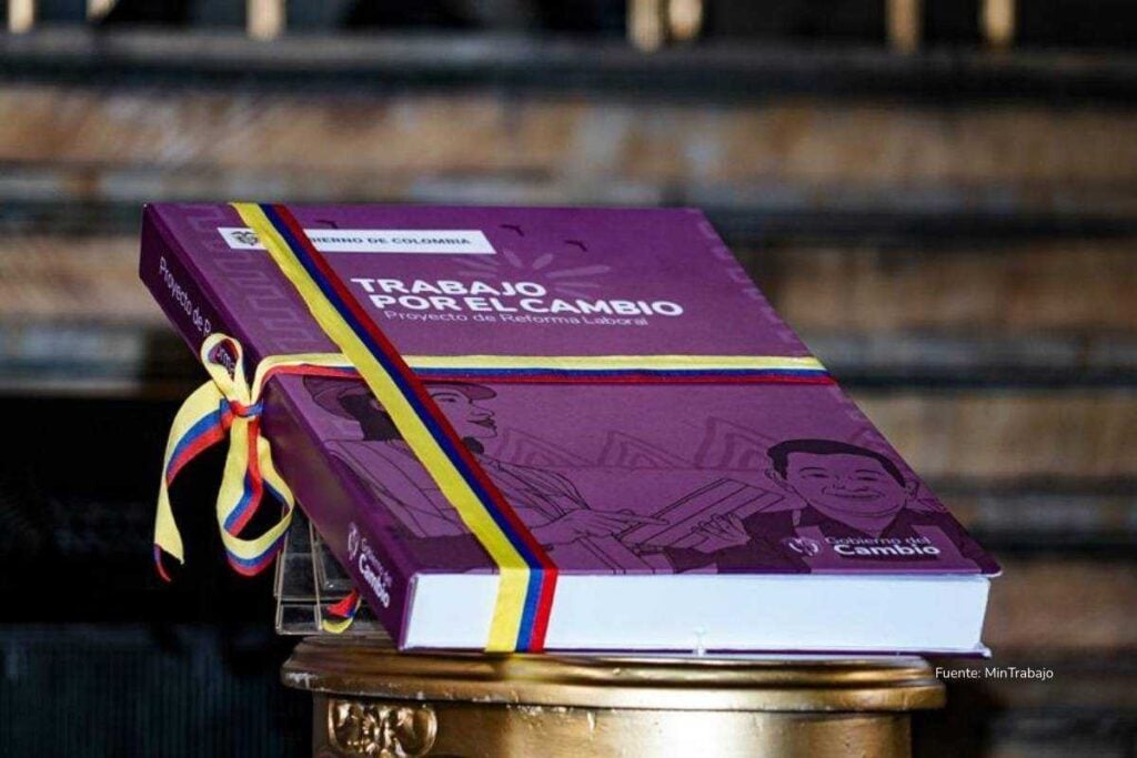 Libro del proyecto de Reforma Laboral “Trabajo por el Cambio”, envuelto con cintas tricolor, posado sobre un podio en un recinto gubernamental.