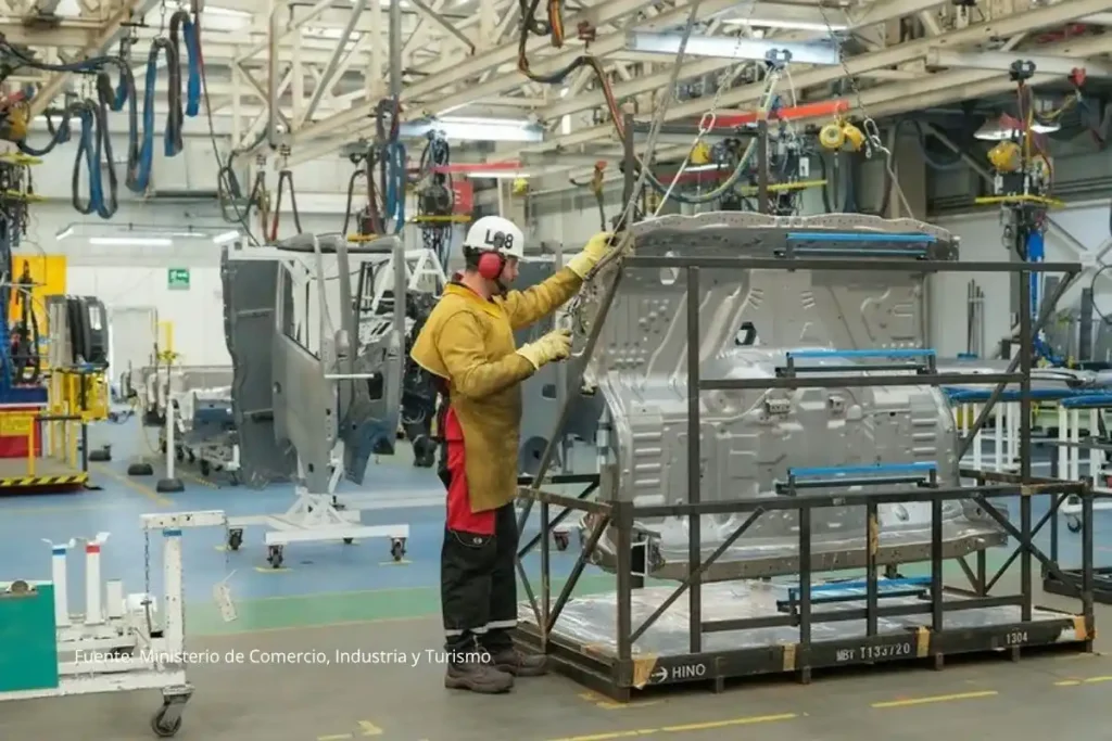 ¿El salario mínimo 2026 podría subir por debajo de la inflación? preocupa productividad negativa 3 Operario de la industria manufacturera manipulando una estructura metálica en una planta de producción automotriz.