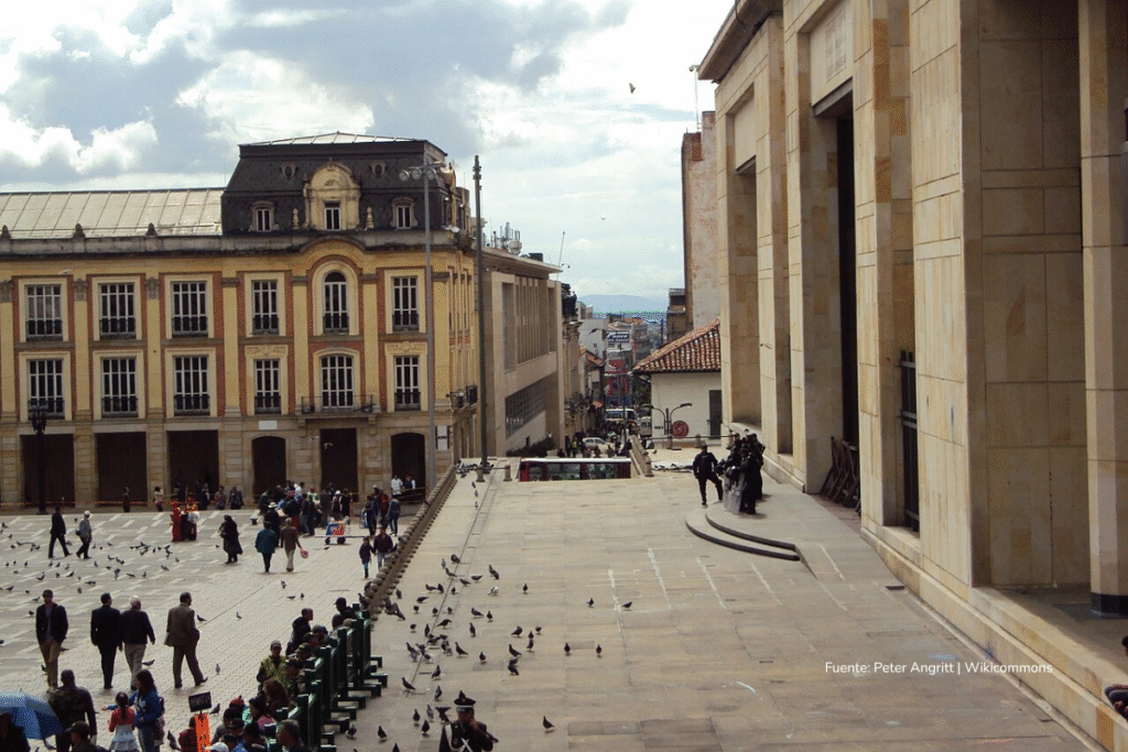 Vista de la Plaza de Bolívar en Bogotá con peatones y edificios históricos, incluyendo el Palacio de Justicia.