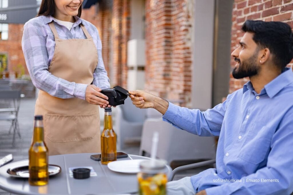 Hombre paga la cuenta con datáfono