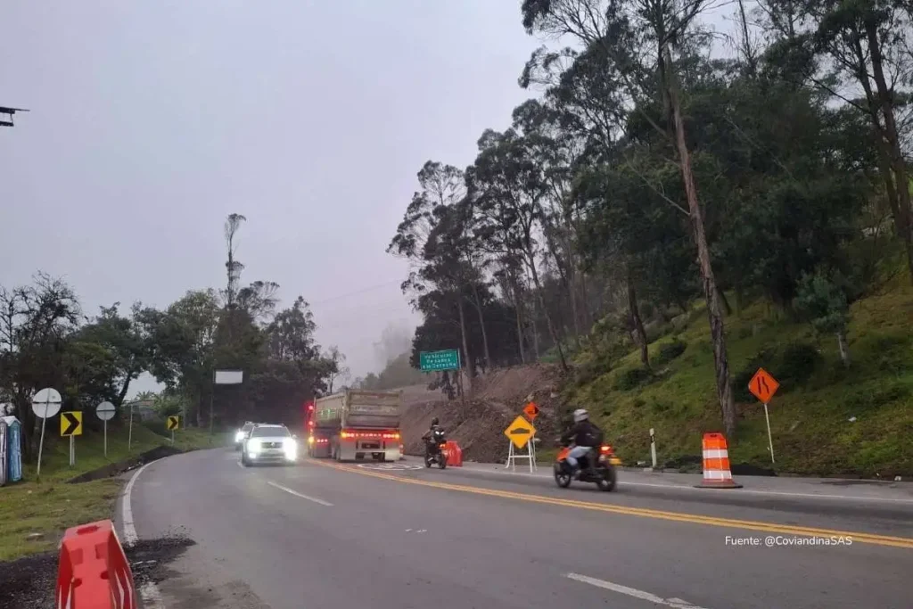 Tramo de la vía al Llano con vehículos circulando entre señalización de obra y neblina en la zona montañosa.
