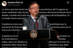 Reforma Tributaria. Una persona ofrece un discurso en un atril con micrófono, mientras detrás se proyecta un mensaje extenso en pantalla relacionado con temas económicos y legislativos.