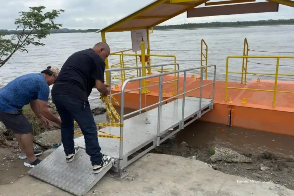 El puerto más eficiente del mundo tarda 8 horas menos que Colombia despachando buques 3 Trabajadores aseguran el acceso a una plataforma flotante con rampa metálica instalada sobre un río como parte de una obra de infraestructura fluvial.