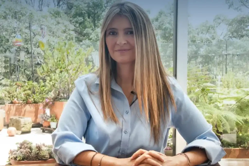 La derecha marcha hacia las elecciones 2026 sin liderazgo único 2 Mujer de cabello largo sentada frente a una mesa, en un espacio interior iluminado con plantas visibles al fondo.