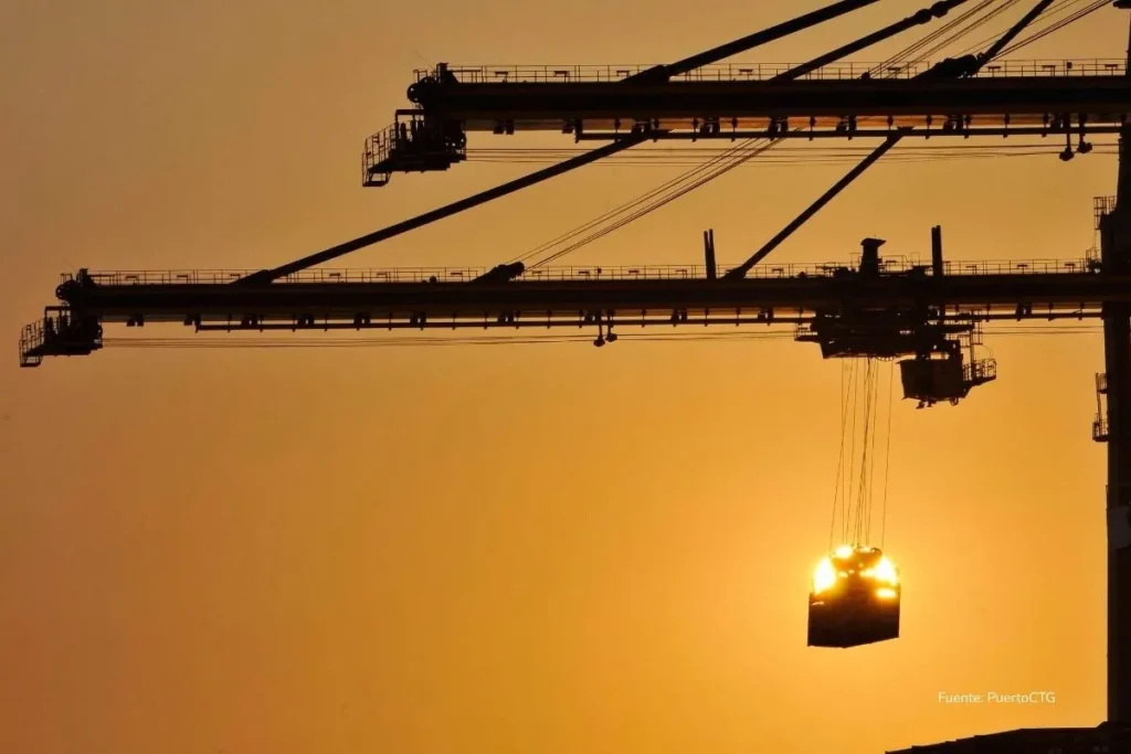 Lo que casi nadie cuenta del Puerto de Cartagena, el segundo puerto más eficiente del planeta 4 Grúa portuaria eleva un contenedor durante una operación de carga y descarga al atardecer en una terminal marítima.