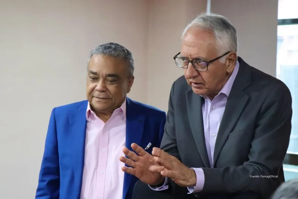 Crisis del Fomag: el sistema improvisado que hoy tiene a ministros en juicio y a miles de maestros sin atención 3 Dos funcionarios conversan y analizan información durante una reunión de trabajo en un espacio institucional.