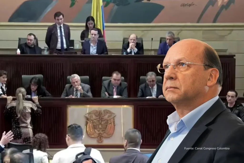 crisis fiscal Colombia. Hombre en traje observando atentamente durante una sesión en el Congreso de Colombia, con legisladores al fondo en pleno debate.