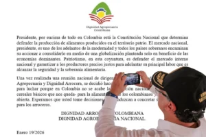 crisis del arroz en Colombia. Persona fotografía un documento de Dignidad Agropecuaria Colombiana sobre soberanía alimentaria y producción nacional