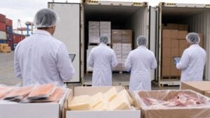 Fotografía editorial horizontal 16:9 de una inspección sanitaria de alimentos importados de origen animal en una zona po