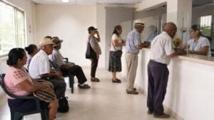 Personas mayores esperan atención en un punto de pago sencillo y tranquilo.