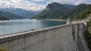 Dos técnicos caminan sobre la presa de una central hidroeléctrica en las montañas de Colombia.