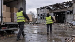 Dos trabajadores humanitarios llevan suministros médicos a una bodega dañada