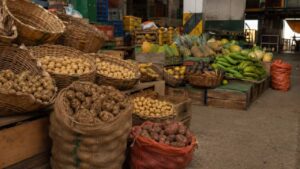 Puesto de papas y frutas en una plaza de mercado colombiana al final de la jornada