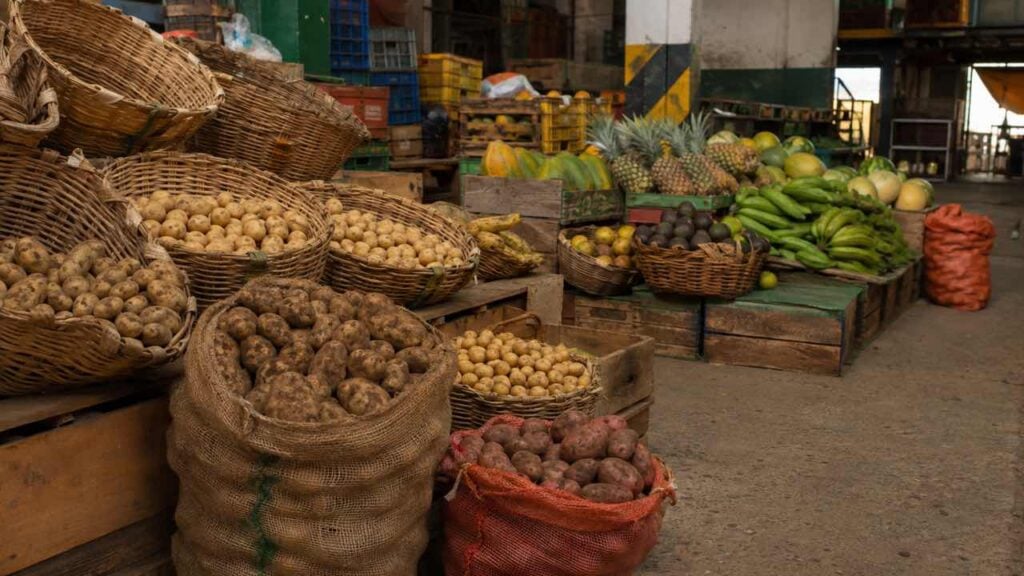 Puesto de papas y frutas en una plaza de mercado colombiana al final de la jornada