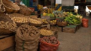 Puesto de papas y frutas en una plaza de mercado colombiana al final de la jornada
