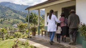 Médica de espaldas atiende a una familia campesina en un puesto de salud de montaña.