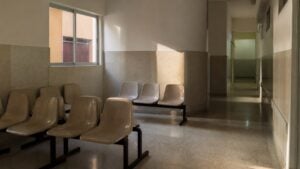 Sala de espera vacía de un centro médico con sillas en fila y luz de tarde