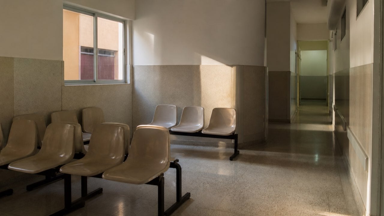 La Procuraduría contó 40.668 tutelas de afiliados a Nueva EPS en un solo trimestre: la EPS tuvo cinco interventores en 24 meses 1 Sala de espera vacía de un centro médico con sillas en fila y luz de tarde