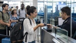 Viajeros presentan documentos ante un funcionario en el control migratorio