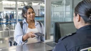 Viajera presenta su pasaporte en un control migratorio de aeropuerto