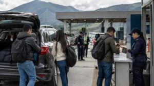 Viajeros colombianos presentan documentos junto a un carro en la frontera