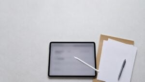 Tableta digital con lápiz óptico y una carpeta con documentos sobre un mostrador de atención