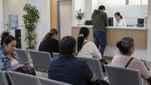Personas esperan atención sentadas en la sala de una sede de salud en Colombia