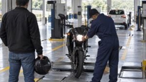 un técnico revisa una motocicleta en la línea de inspección de un centro de diagnóstico automotor.