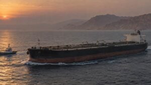 Adultos observan operaciones marítimas y petroleras en una sala genérica frente a un puerto.