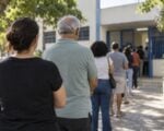 Votantes hacen fila frente a un puesto de votación en una calle de una ciudad brasileña.